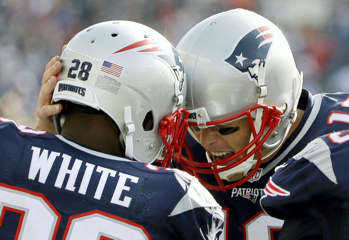 Patriots running back James White (28) celebrates his touchdown with quarterback Tom Brady on Sunday.