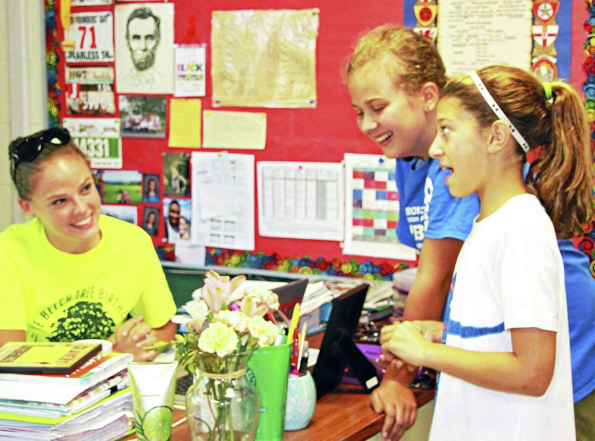 Independent Day School teacher Katy Carlebach of Middletown, left, laughs with two of her students. The avid runner was recently chosen as part of the Permanent Commission on the Status of Women’s Young Women Rising Project.