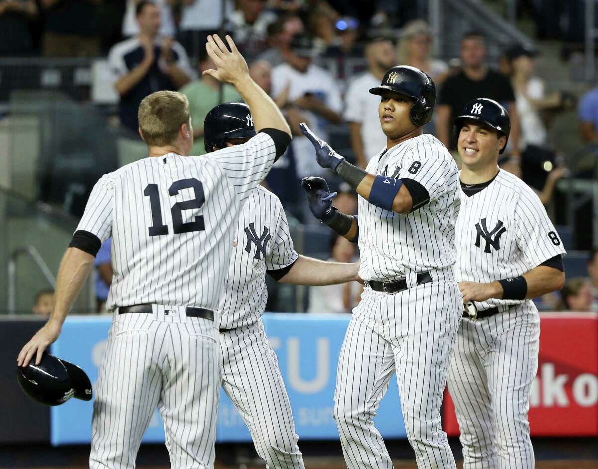 Starlin Castro, second from right, is greeted by teammates Mark Teixeira, right, Chase Headley, left, and Brian McCann after hitting a grand slam during the third inning on Friday.