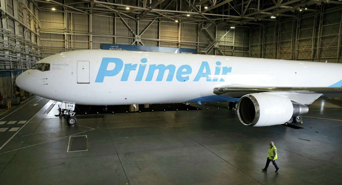 A worker walks past a Boeing 767 with an Amazon.com “Prime Air” livery on display Thursday in a Boeing hangar in Seattle.