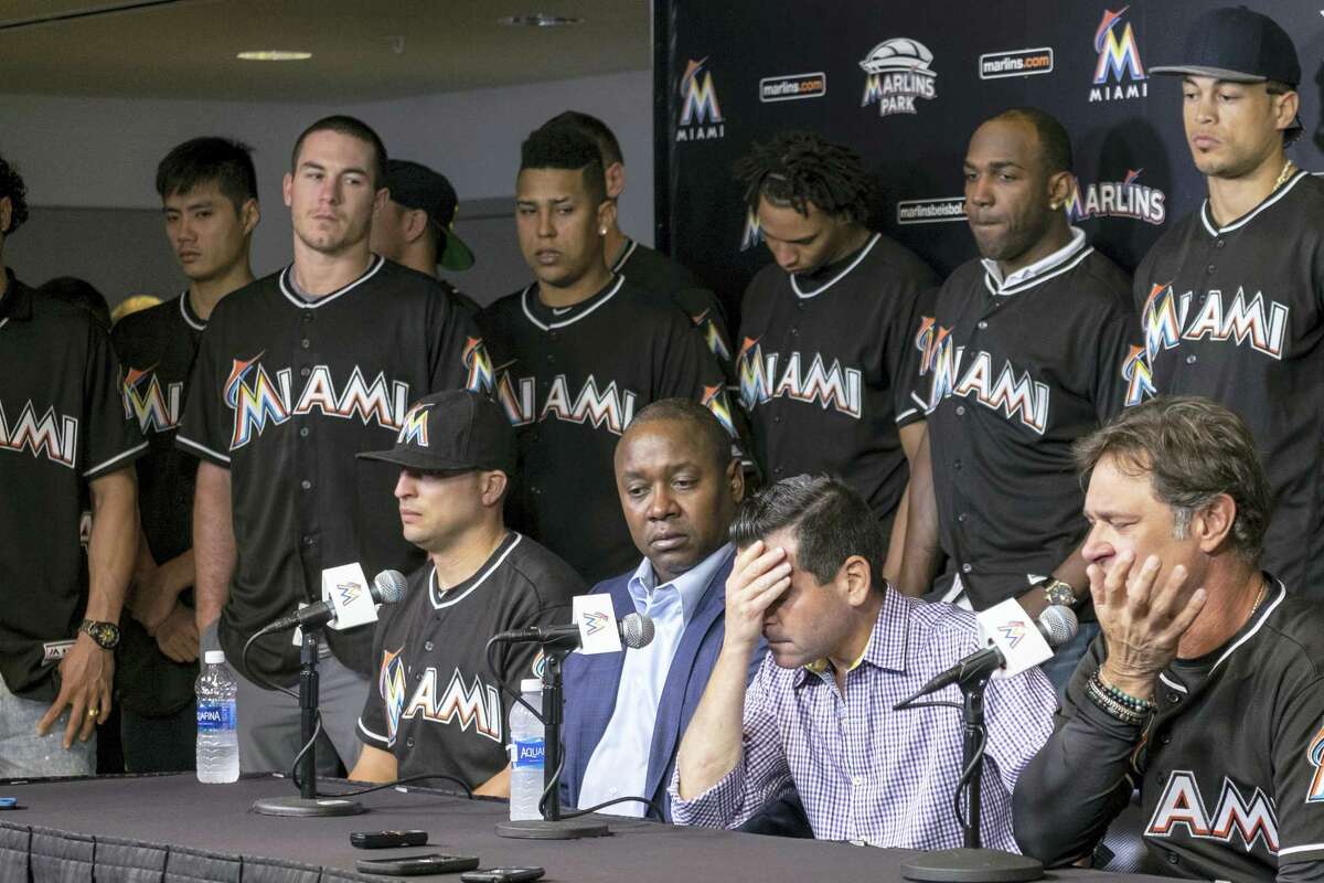 David P. Samson, center, president of the Miami Marlins, covers his face during press conference to announce the death of Marlins pitcher Jose Fernandez.