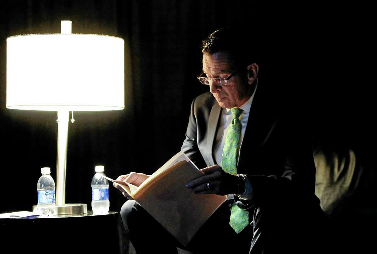 Gov. Dannel P. Malloy reads over his speech in a private area backstage while waiting as delegates nominate him as the Democratic candidate for governor at the Connecticut Democratic Convention, Friday, May 16, 2014, in Hartford, Conn. (AP Photo/Jessica Hill)