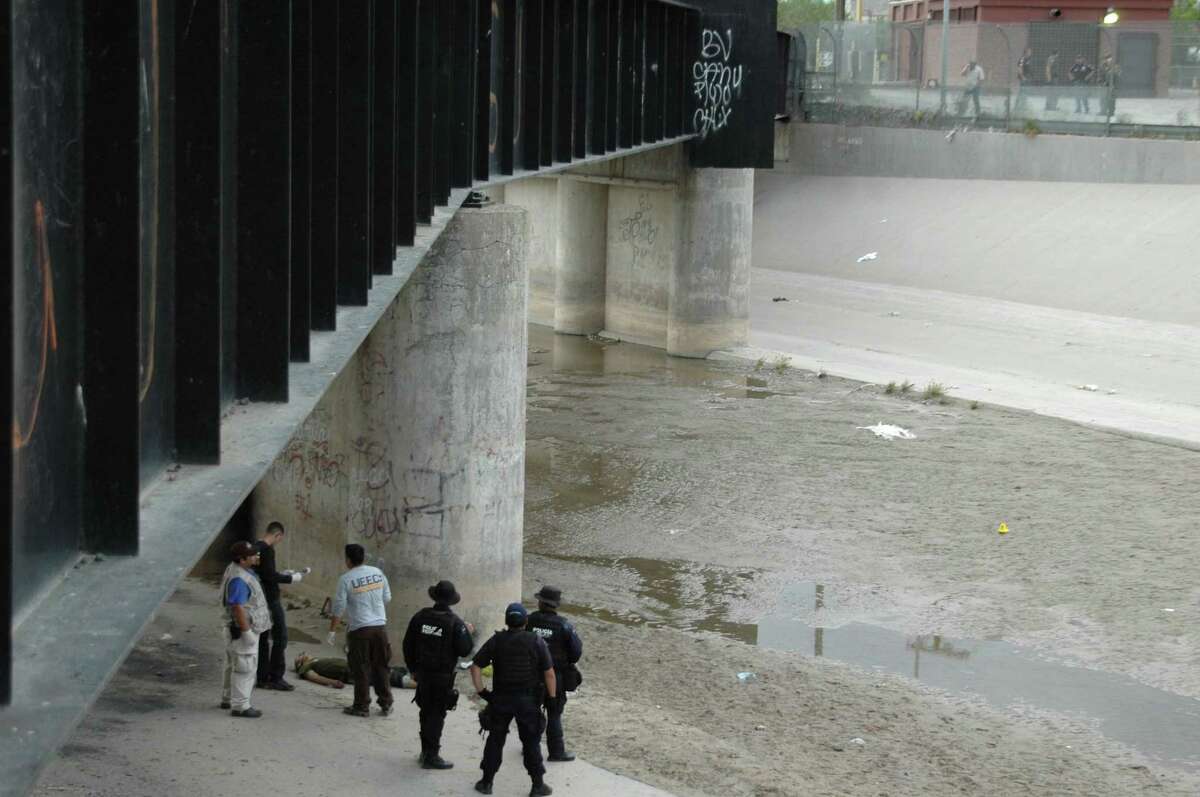 FILE - In this June 7, 2010 file photo, Mexican federal police and forensic experts stand next to the body of Sergio Adrian Hernandez Huereca, 15, under the Paso Del Norte border bridge, as U.S. officials watch from the U.S. side at right, in Ciudad Juarez, northern Mexico. On Wednesday, Jan 21, 2015, a federal appeals court in New Orleans revisits the question of whether the Mexican teenagerís rights were violated under the U.S. Constitution when he was killed in his home country by a bullet allegedly fired by a federal agent from across the border in Texas.(AP Photo)