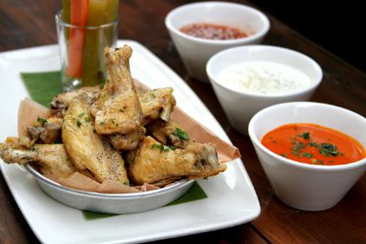 Don't toss your chicken wings in sauce. It makes them soggy, says the Gabe Caliendo, the executive chef at Lazy Dog restaurant in Concord, and it limits your guests' sauce choices. Instead serve the sauces, such as Frank's Red Hot (front), Blue Cheese Dressing and a Thai Sweet Chile Sauce, on the side.