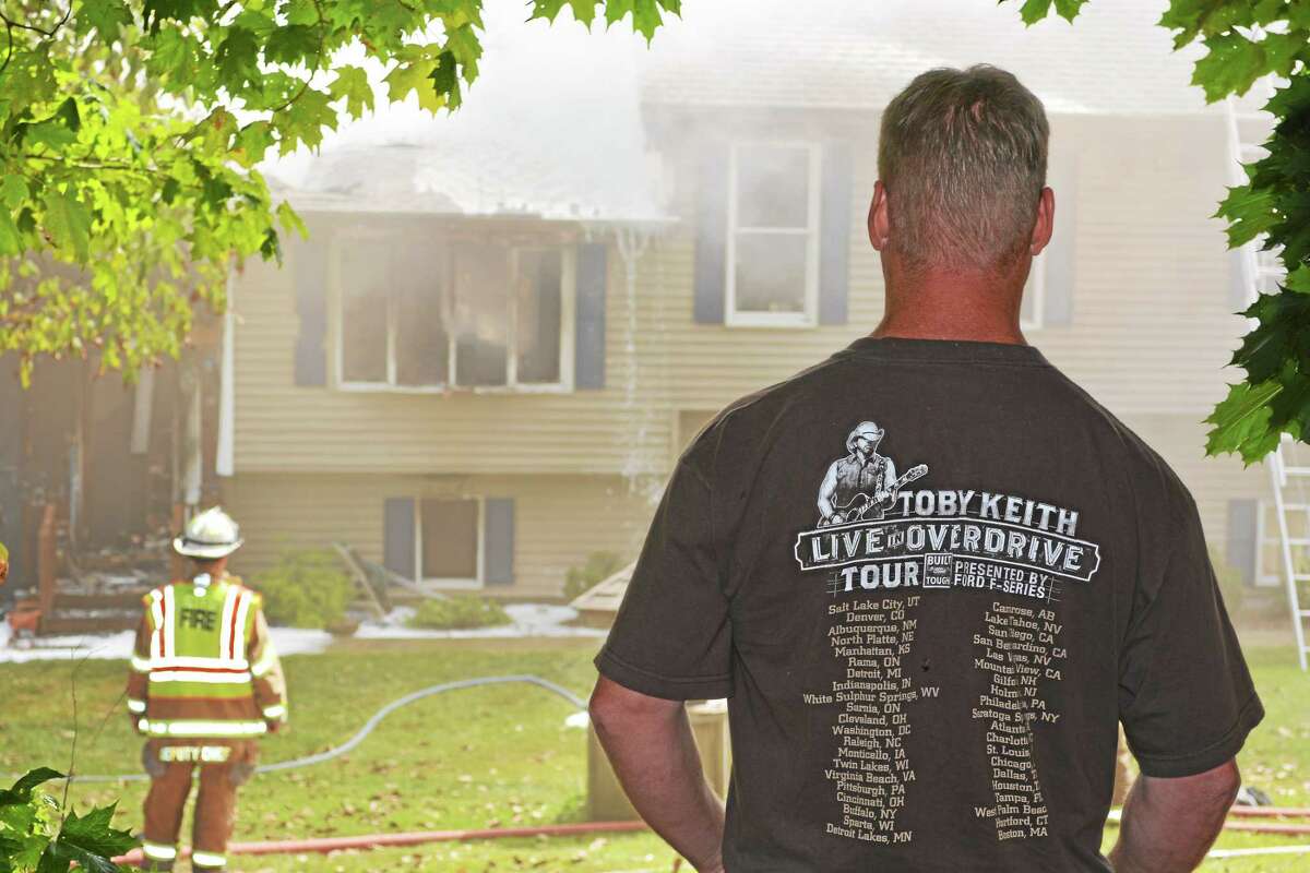 Kathleen Schassler - The Middletown Press A fire on Jackson Hill Road in Middletown touched off Tuesday just before noon. Here, Dan Quincy speaks to Middlefield fireman about an addition to his house.