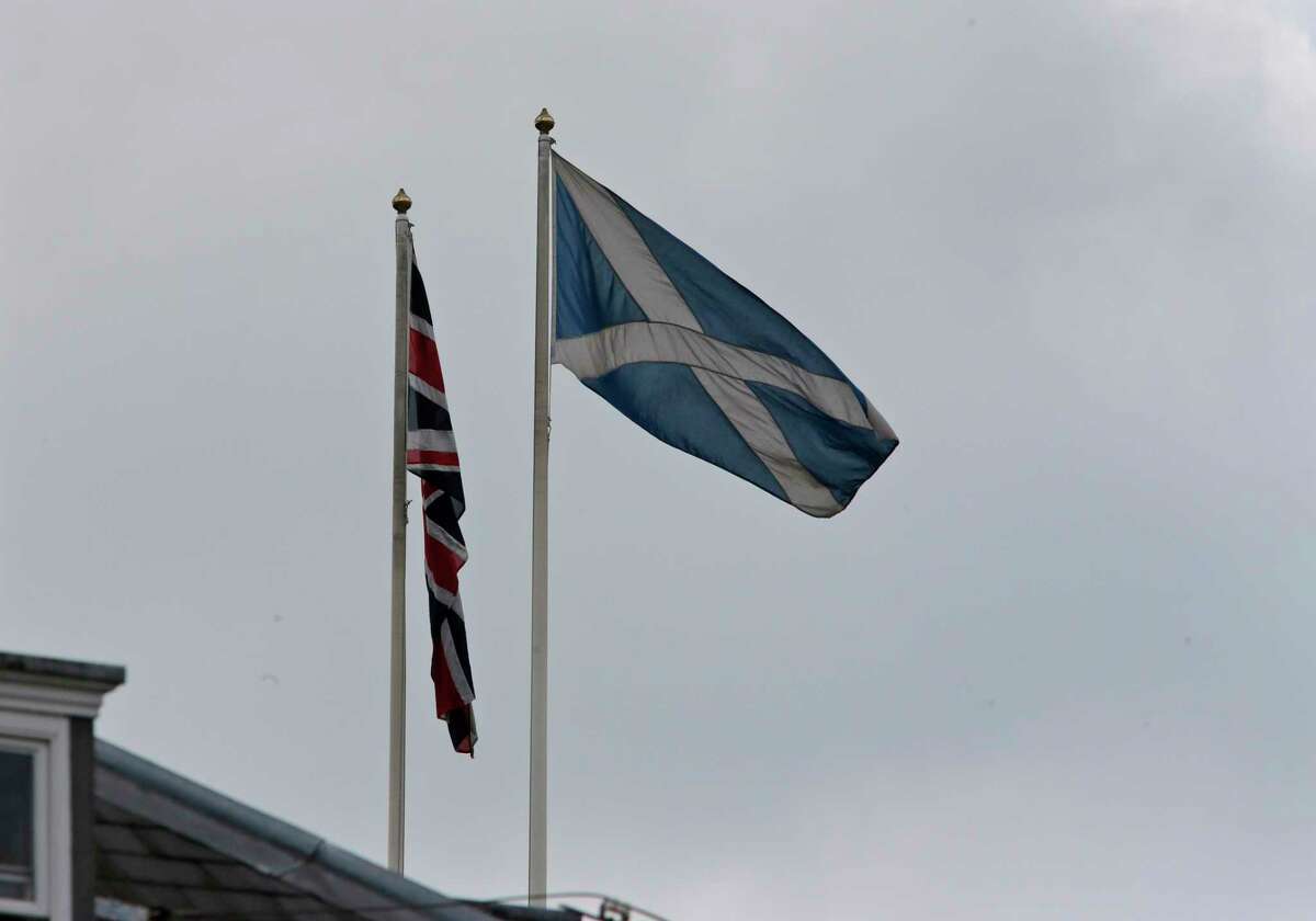 The Saltire, right, flies along with the Union Jack on a government building at Whitehall in central London, Wednesday, Sept. 10, 2014. British Prime Minister David Cameron abandoned party politics for pure emotion Wednesday, imploring Scots not to break his heart by voting to become independent from the United Kingdom. Conservative Party chief Cameron, Labour leader Ed Miliband and Liberal Democrat chief Nick Clegg all pulled out of a weekly House of Commons question session in London to make a late campaign dash to Scotland as polls suggest the two sides are neck-and-neck ahead of next week's independence referendum that could break Scotland's 307-year union with the kingdom. (AP Photo/Lefteris Pitarakis)