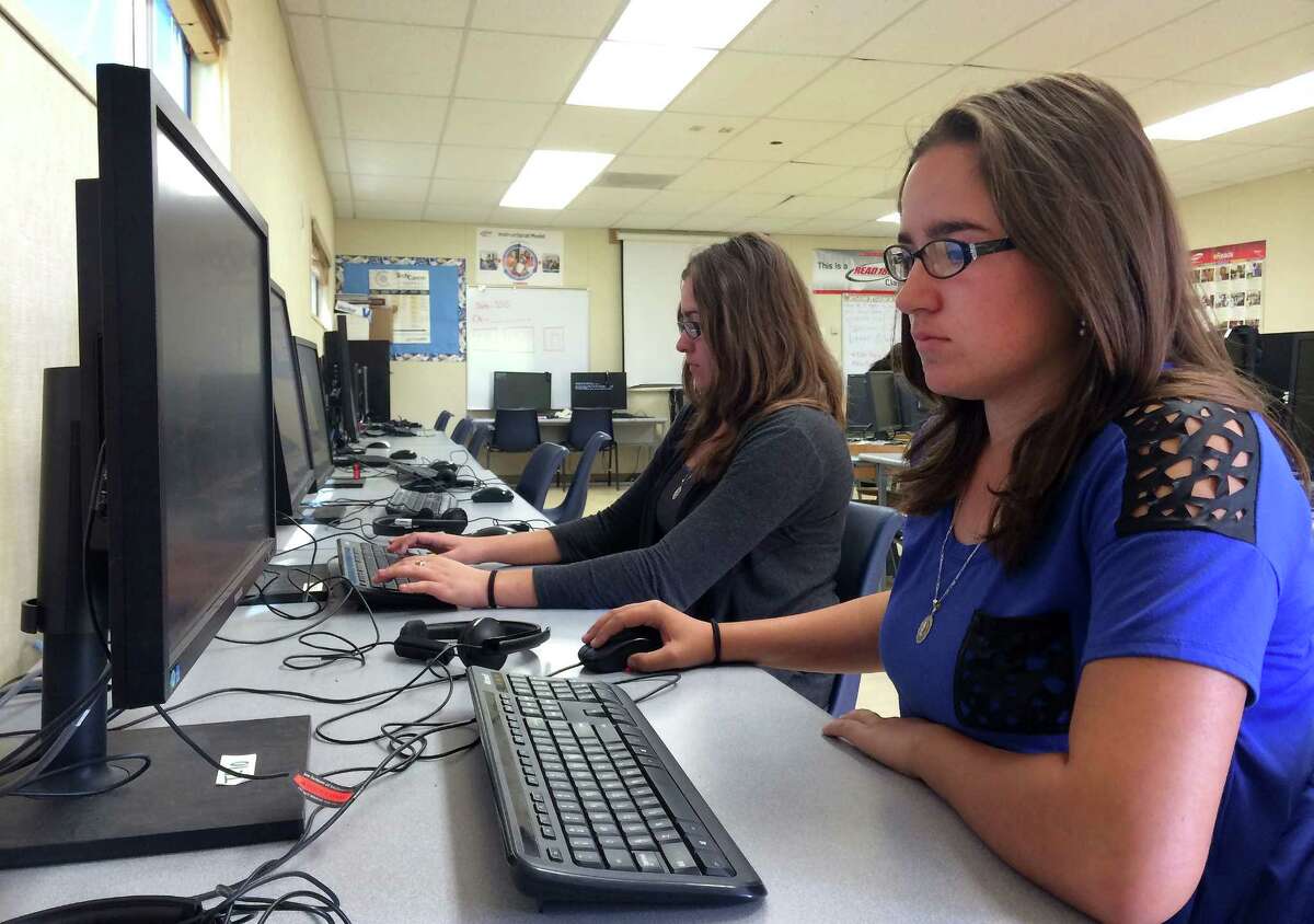 In this April 30, 2015 photo, Leticia Fonseca, 16, left, and her twin sister, Sylvia Fonseca, right, work in the computer lab at Cuyama Valley High School after taking the new Common Core-aligned standardized tests in New Cuyama, Calif.