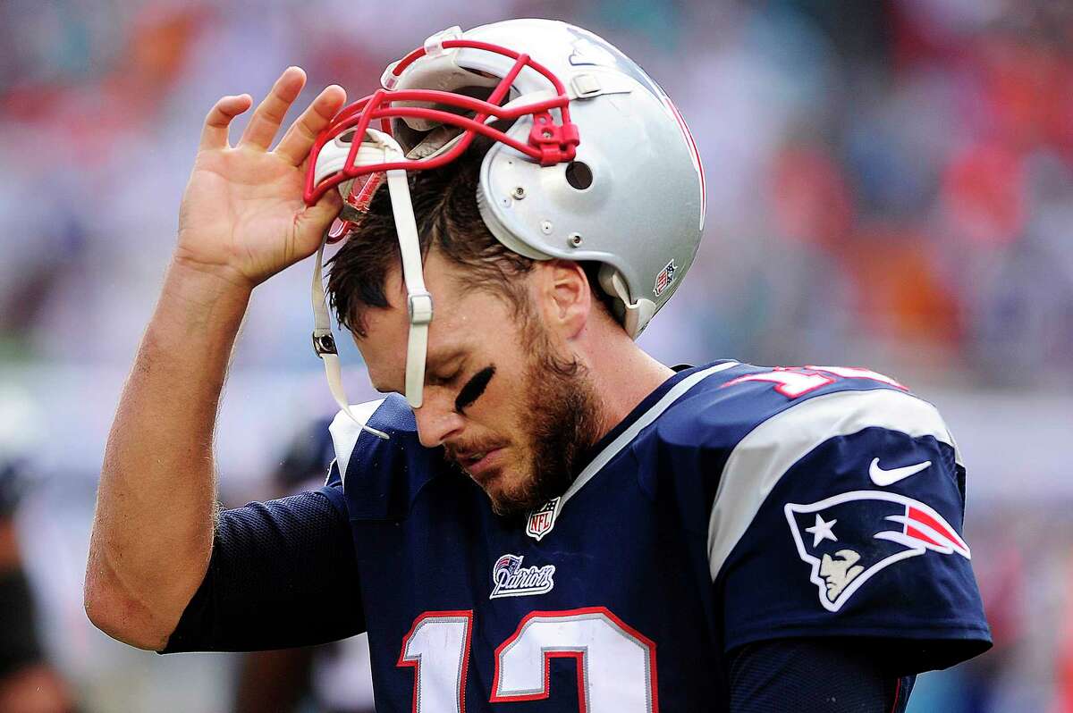 New England Patriots quarterback, Tom Brady, removes his helmet after failing to pick up a first down against the Miami Dolphins late in the fourth quarter Sunday, Sept. 7, 2014 at Sun Life Stadium in Miami Gardens, Fla. Miami beat New England 33-20.
