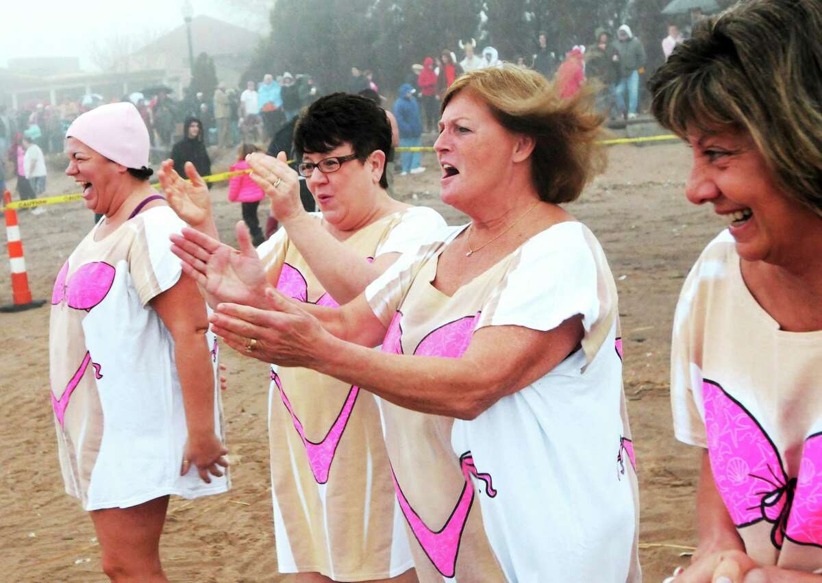 From left, Maria Sutton, Bertha Francis, Suzan Beirne and Cheryl Segaline, all friends from West Haven, cheer fellow participants on Saturday at the beach behind the Savin Rock Conference Center in West Haven, before the 14th annual Icy Plunge for the Cure, which benefits breast cancer research.