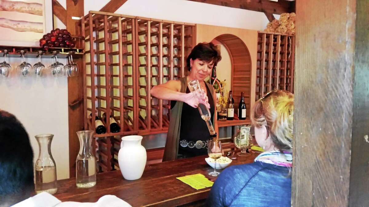 N.F. Ambery — Special to the Register Citizen Vineyard employee Susan Robinson serves wine during tastings at the Haight-Brown Vineyards in Litchfield at the Harvest Festival in September.