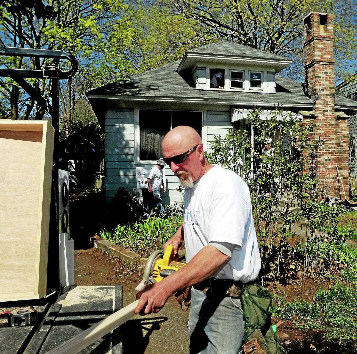Union carpenter Tom Robison of Ansonia, a HomeFront Inc. volunteer, prepares to cut wood during a renovation project Saturday at the Malewicki residence on Whitney Avenue in Milford.