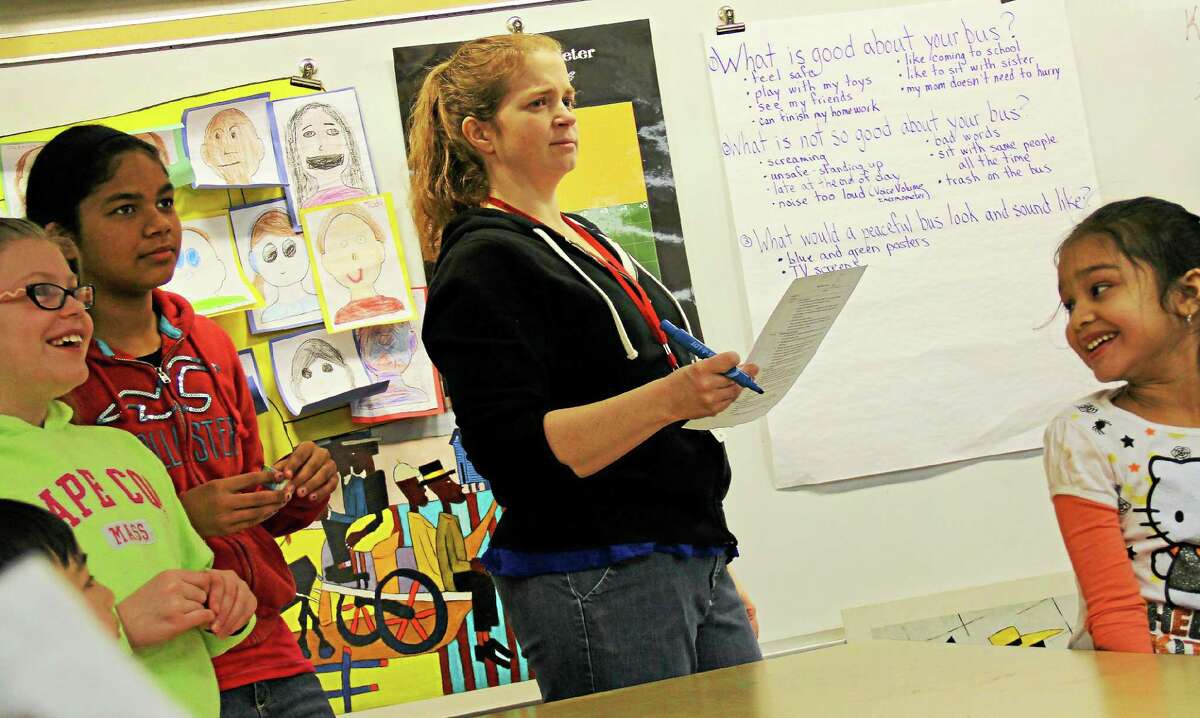 Teacher Carrie Nelson works with students on Friday at Lawrence Elementary School during the Peaceful Bus program.