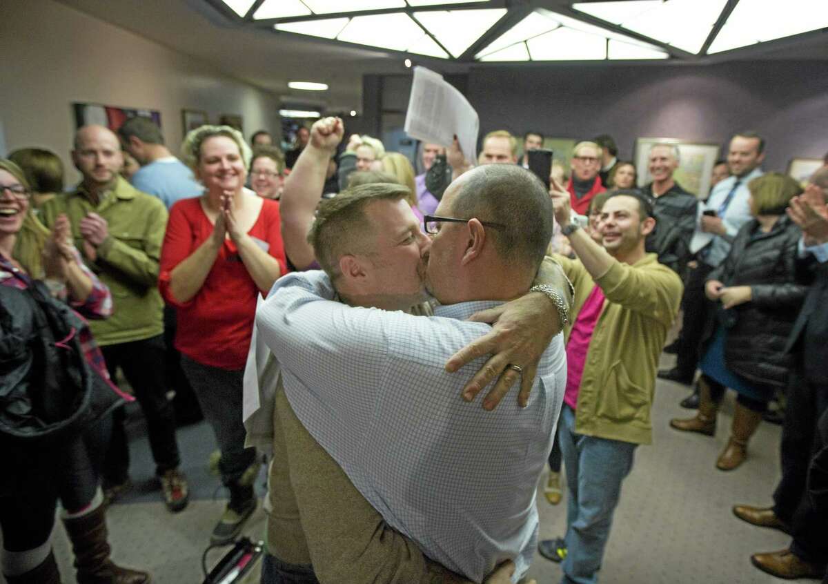 In this Dec. 20, 2013 file photo, Chris Serrano, left, and Clifton Webb kiss after being married, as people wait in line to get licenses outside of the marriage division of the Salt Lake County Clerk’s Office, in Salt Lake City. On Wednesday, a federal appeals court ruled for the first time that states must allow gay couples to marry, finding the Constitution protects same-sex relationships and putting a remarkable legal winning streak across the country one step closer to the U.S. Supreme Court. The decision from a three-judge panel in Denver upheld a lower court ruling that struck down Utah’s gay marriage ban.