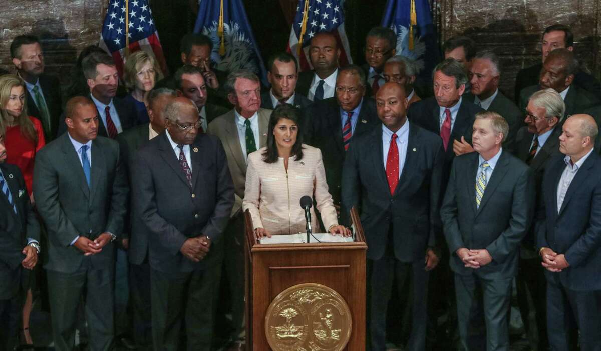 TIM DOMINICK/THE STATE VIA AP South Carolina Gov. Nikki Haley, center, calls for legislators to remove the Confederate flag from the Statehouse grounds during a news conference in the South Carolina State House in Columbia, S.C., Monday. Those surrounding her as she spoke included state legislators of both parties.