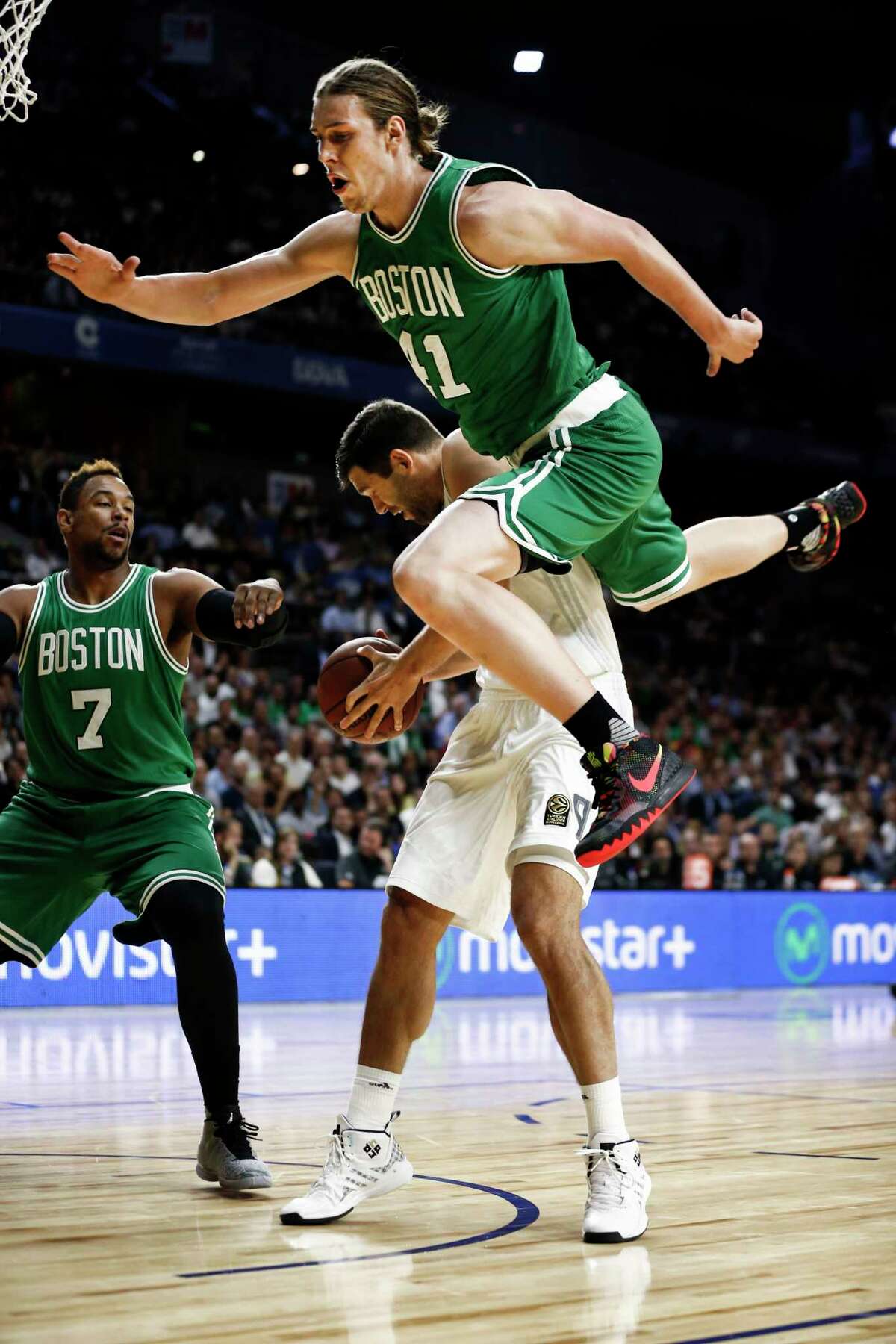 The Boston Celtics’ Kelly Olynyk, top, falls over Real Madrid’s Felipe Reyesd during Thursday’s game against Real Madrid at the Barclaycard Centre sport arena in Madrid, Spain.