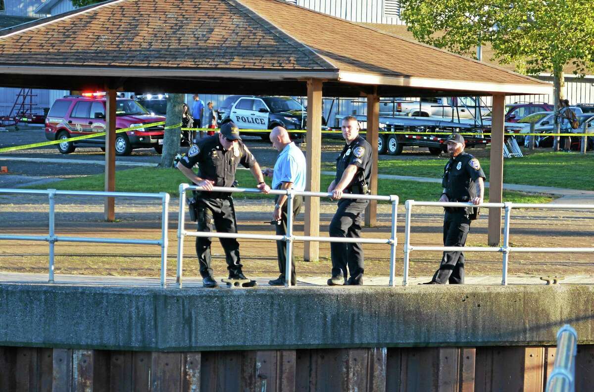 Middletown police officers stand along the railing at Harbor Park. The entire area from the boathouse to the boardwalk at the rear entrance of the Mattabesett Canoe Club was cordoned off with police tape Tuesday evening.