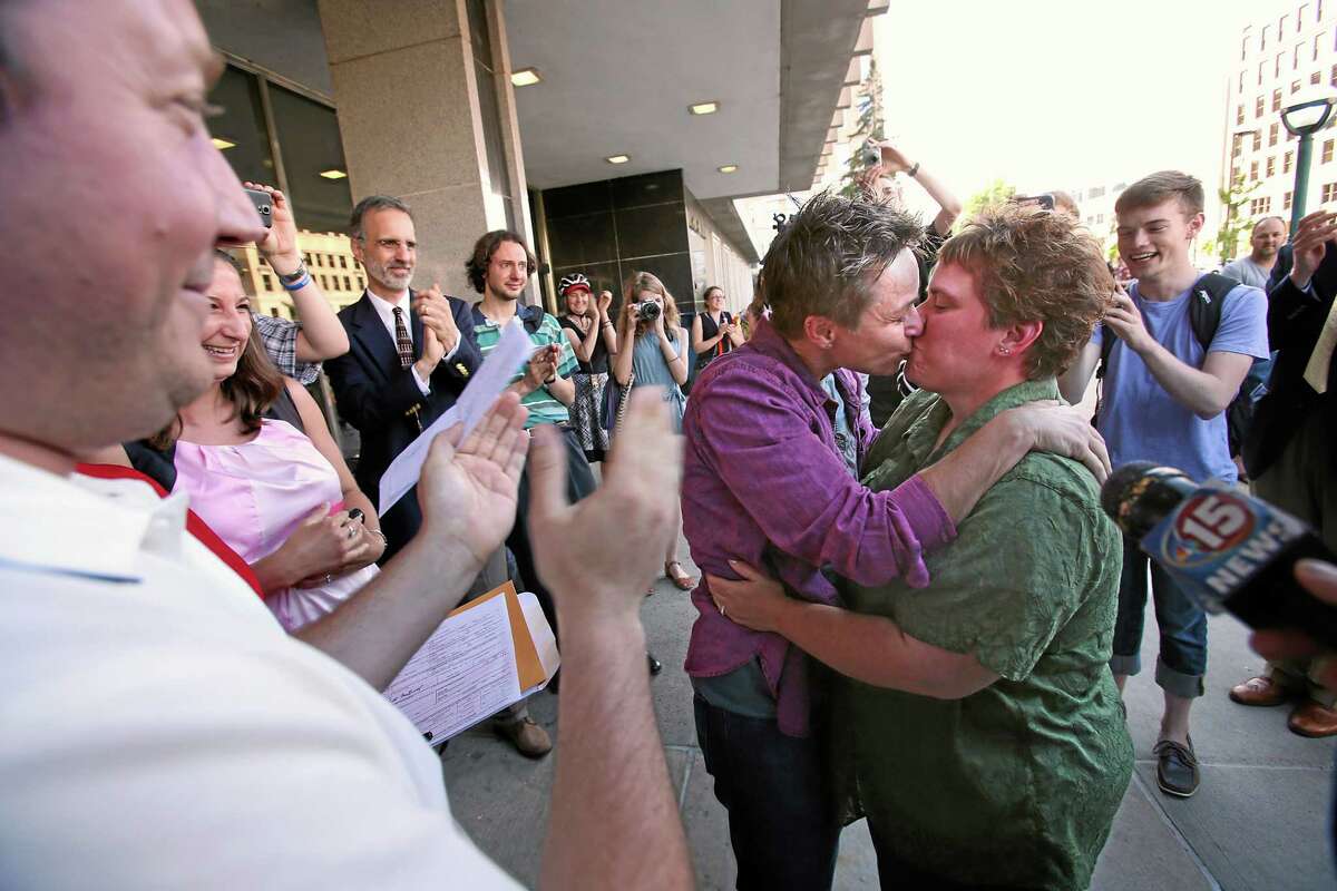 Shari Roll, left, and Renee Currie, of Madison, Wis., kiss as they were married by officiant Mike Quito on the steps of the City-County Building on Friday, June 6, 2014, in Madison, Wis., after a federal judge struck down a ban on same-sex marriage in the state. The couple have had a civil union for 10 years and have been together since 2003.