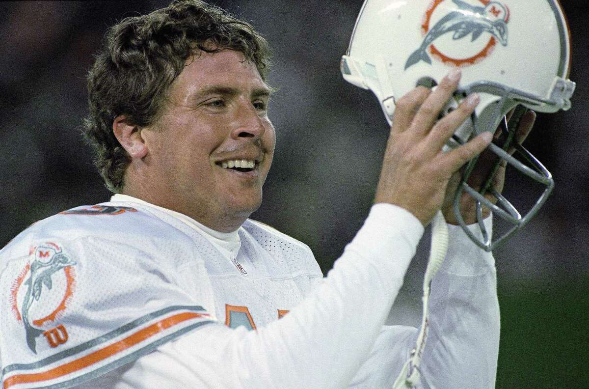 In this 1994, file photo, Miami Dolphins quarterback Dan Marino removes his helmet after throwing the winning touchdown against the New York Jets.