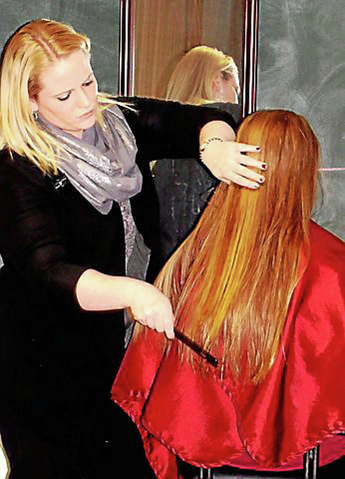 A stylist from The Cut Above hair salon in Cromwell shows a teen how to style her hair. A similar program, Decked out for December, at the library is offering tips for makeup, hair and dress for the upcoming holidays.