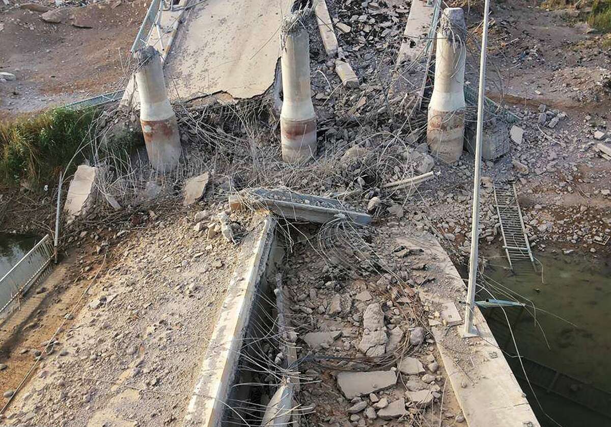 This photo taken Wednesday, June 3, 2015, shows a destroyed bridge on the Euphrates river in northern Ramadi, Iraq. The Islamic State group destroyed the bridge with a car bomb to cut the northern entrance to the city, locals said. (AP Photo)