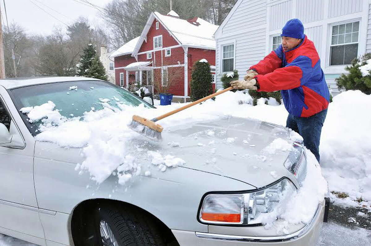 (Peter Casolino ó New Haven Register) Earl Vaughn clears off his car, still covered in snow from Thursdays storm, as snow beings to fall early Saturday afternoon in New Haven. pcasolino@NewHavenRegister ¬