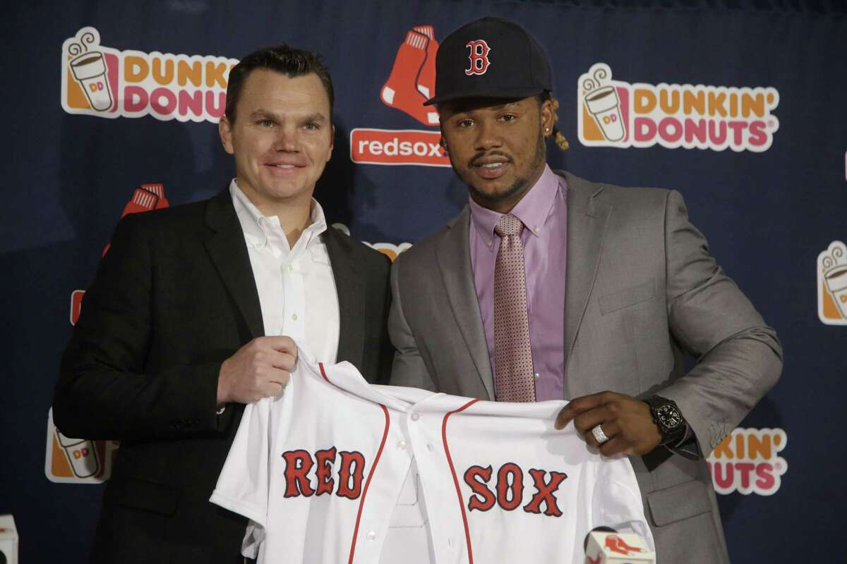 Newly acquired Boston Red Sox infielder Hanley Ramirez and general manager Ben Cherington pose for a photo on Tuesday at Fenway Park in Boston. Register sports columnist Chip Malafronte points out the Red Sox have been spending and the Blue Jays have been dealing while the Yankees, saddled with awful contracts, are sitting tight.