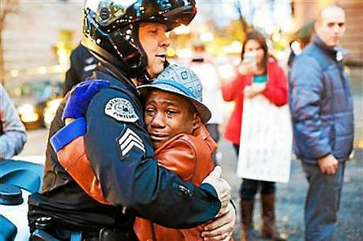 A police officer in Portland, Ore., hugs a young protester who was carrying a sign that said, “Free Hugs.”
