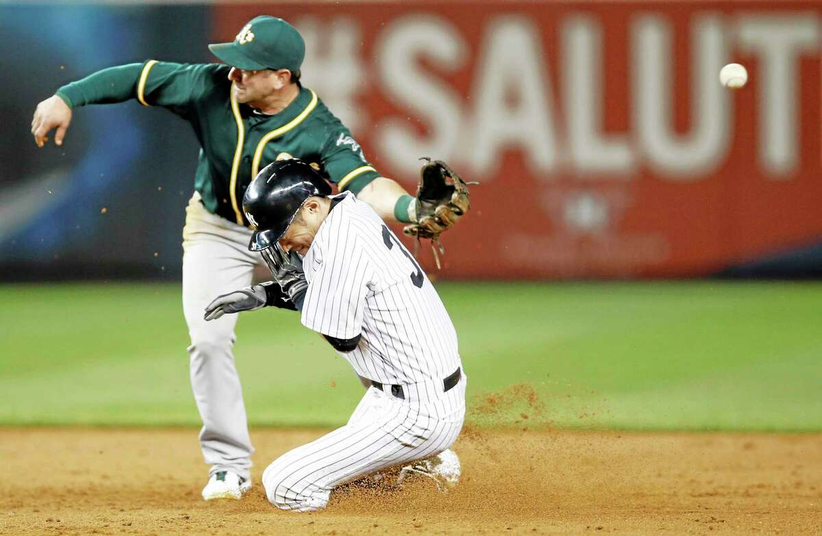 The throw hops past Oakland Athletics second baseman Nick Punto as New York Yankees Ichiro Suzuki (31) is safe stealing second on a sixth inning stolen base in a baseball game at Yankee Stadium in New York, Wednesday, June 4, 2014. Ichiro advanced to third on the error. (AP Photo/Kathy Willens)