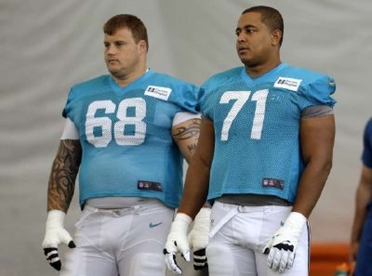 In this July 24, 2013, file photo, Miami Dolphins guard Richie Incognito (68) and tackle Jonathan Martin (71) stand on the field during NFL football practice in Davie, Fla.
