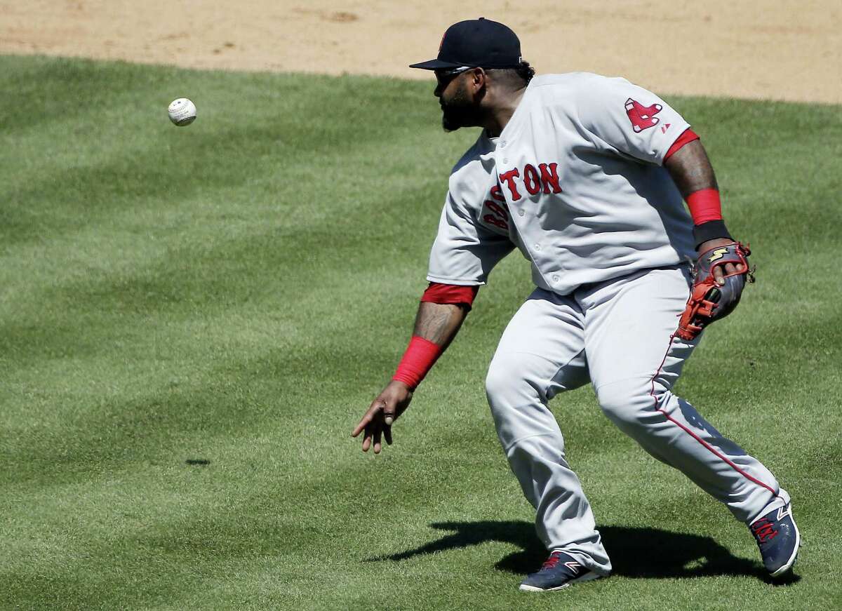 Boston Red Sox third baseman Pablo Sandoval mishandles the ball while attempting to throw to first during Sunday’s game against the Rangers in Arlington, Texas.