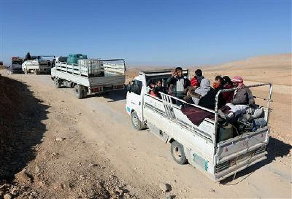 Syrian citizens with their belongings in trucks flee Yabroud, the last rebel stronghold in Syria's mountainous Qalamoun region, as they drive toward the Lebanese-Syrian.