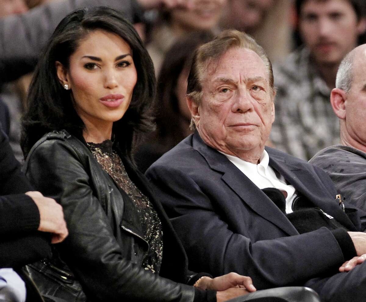 FILE - In this Dec. 19, 2011, file photo, Los Angeles Clippers owner Donald Sterling, right, sits with V. Stiviano as they watch the Clippers play the Los Angeles Lakers during an NBA preseason basketball game in Los Angeles. Sterling's wife, Shelly Sterling, is going after the $2.5 million in real estate and cars her husband lavished on V. Stiviano in a trial scheduled to begin Wednesday, March 25, 2015, in Los Angeles Superior Court. (AP Photo/Danny Moloshok, File)