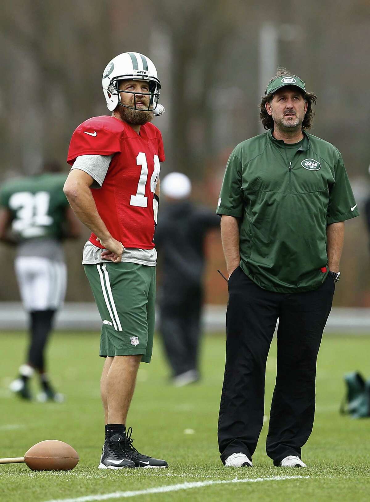 New York Jets quarterback Ryan Fitzpatrick talks with trainer John Mellody during Wednesday’s practice.