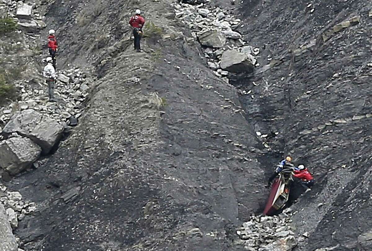 Rescue workers work on debris at the plane crash site near Seyne-les-Alpes, France, Wednesday, March 25, 2015, after a Germanwings jetliner crashed Tuesday in the French Alps. French investigators cracked open the badly damaged black box of a German jetliner on Wednesday and sealed off the rugged Alpine crash site where 150 people died when their plane on a flight from Barcelona, Spain to Duesseldorf, Germany, slammed into a mountain.