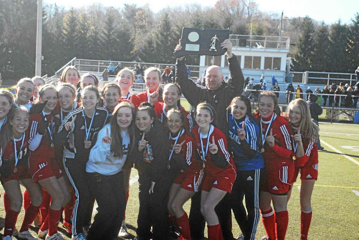 Portland girls soccer coach Sandy Booth holds up the state championship plaque after the Highlanders 2-1 win over Housatonic Saturday at Waterburyís Municipal Stadium.