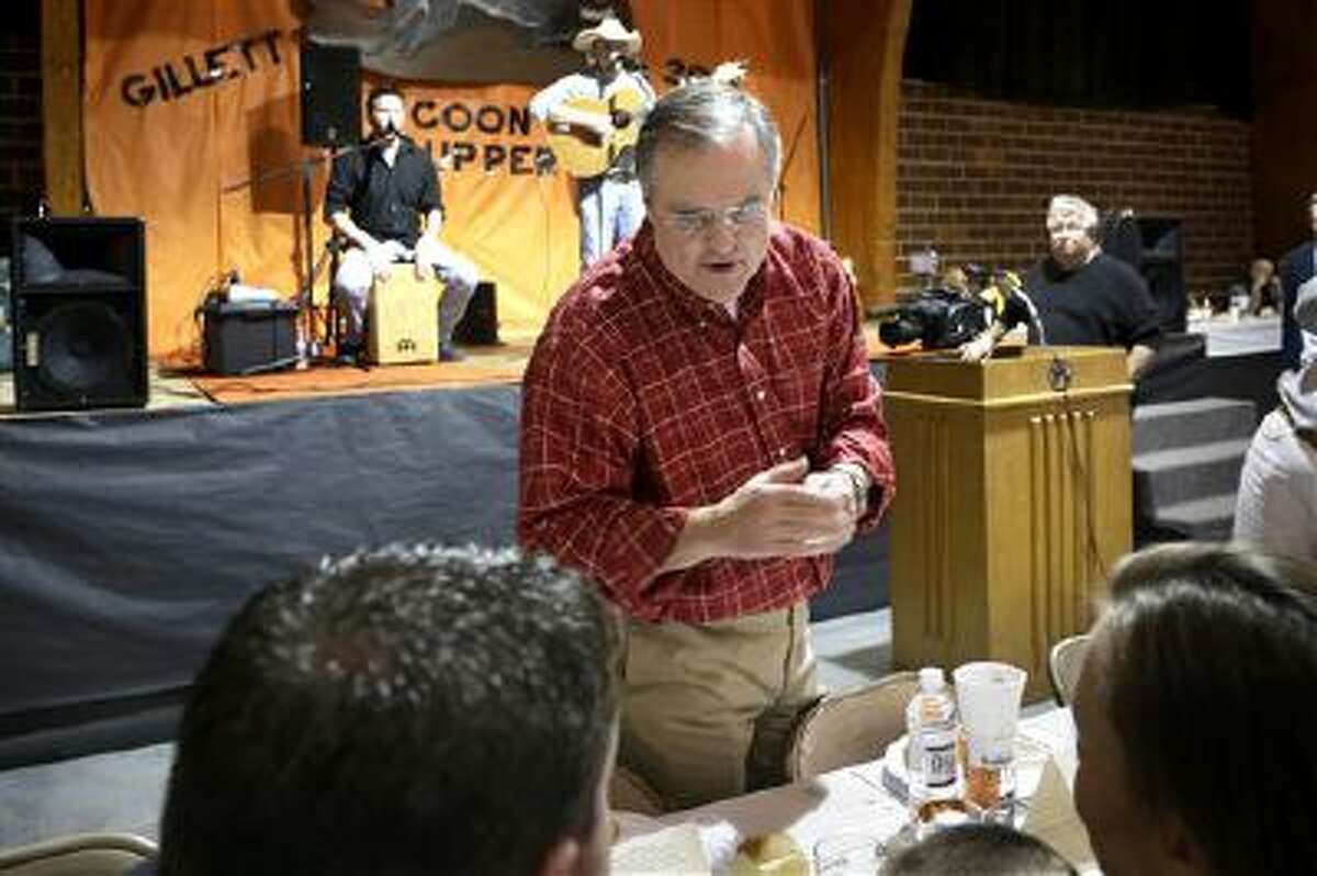 In this photo taken Saturday, Jan. 11, 2014, U.S. Sen. Mark Pryor, D-Ark., speaks to people at the Gillett Coon Supper in Gillett, Ark., as a band plays on a nearby stage.