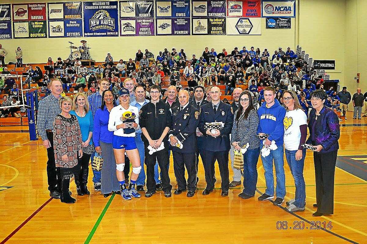 Courtesy University of New Haven Women's Volleyball Ashley Dalton stands with "Ashley's Angels," the first responders who helped save her life on August 30 when she collapsed in Middletown.