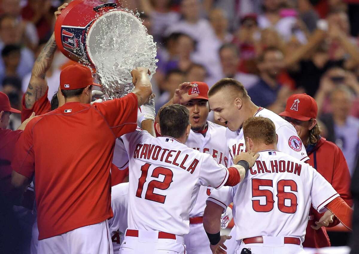 Teammates celebrate with Mike Trout as he touches home after hitting a solo home run in the bottom of the ninth inning against the Boston Red Sox in the Los Angeles Angels’ 1-0 win on Friday night in Anaheim, Calif.