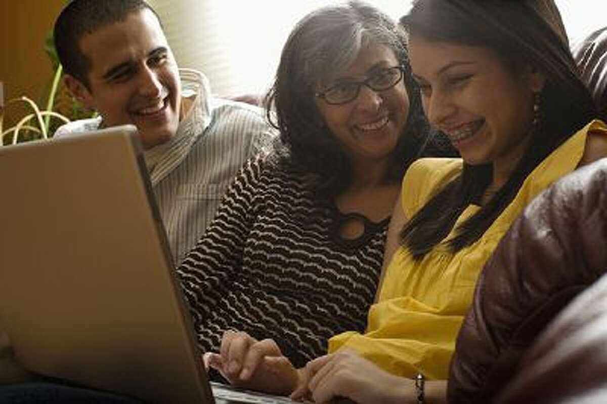 family laughing using laptop
