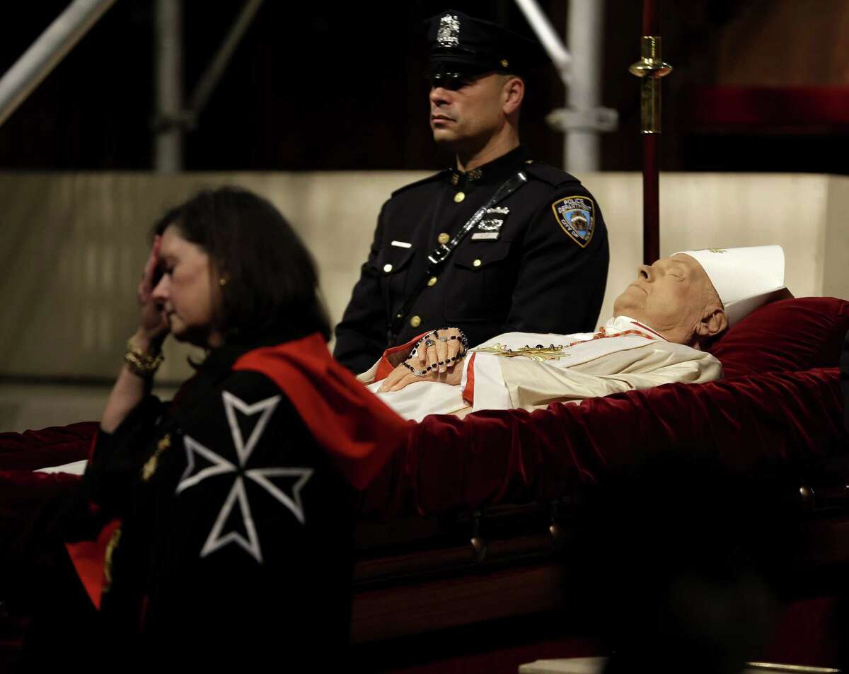 Officals stand around the body of Cardinal Edward Egan at a public viewing in St. Patrick's Cathedral in New York, Monday, March 9, 2015. Egan played a prominent role in New York City after the Sept. 11 terror attacks, and now New Yorkers are preparing to pay respects to the former archbishop after his death last week. (AP Photo/Seth Wenig)