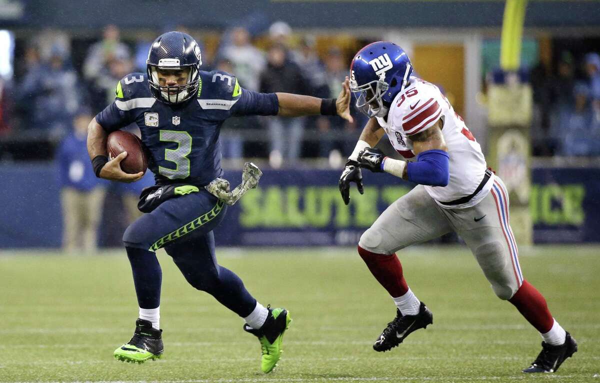 Seattle Seahawks quarterback Russell Wilson (3) gets ready to push off of New York Giants' Quintin Demps during the second half of an NFL football game, Sunday, Nov. 9, 2014, in Seattle. The Seahawks won 38-17. (AP Photo/Elaine Thompson)