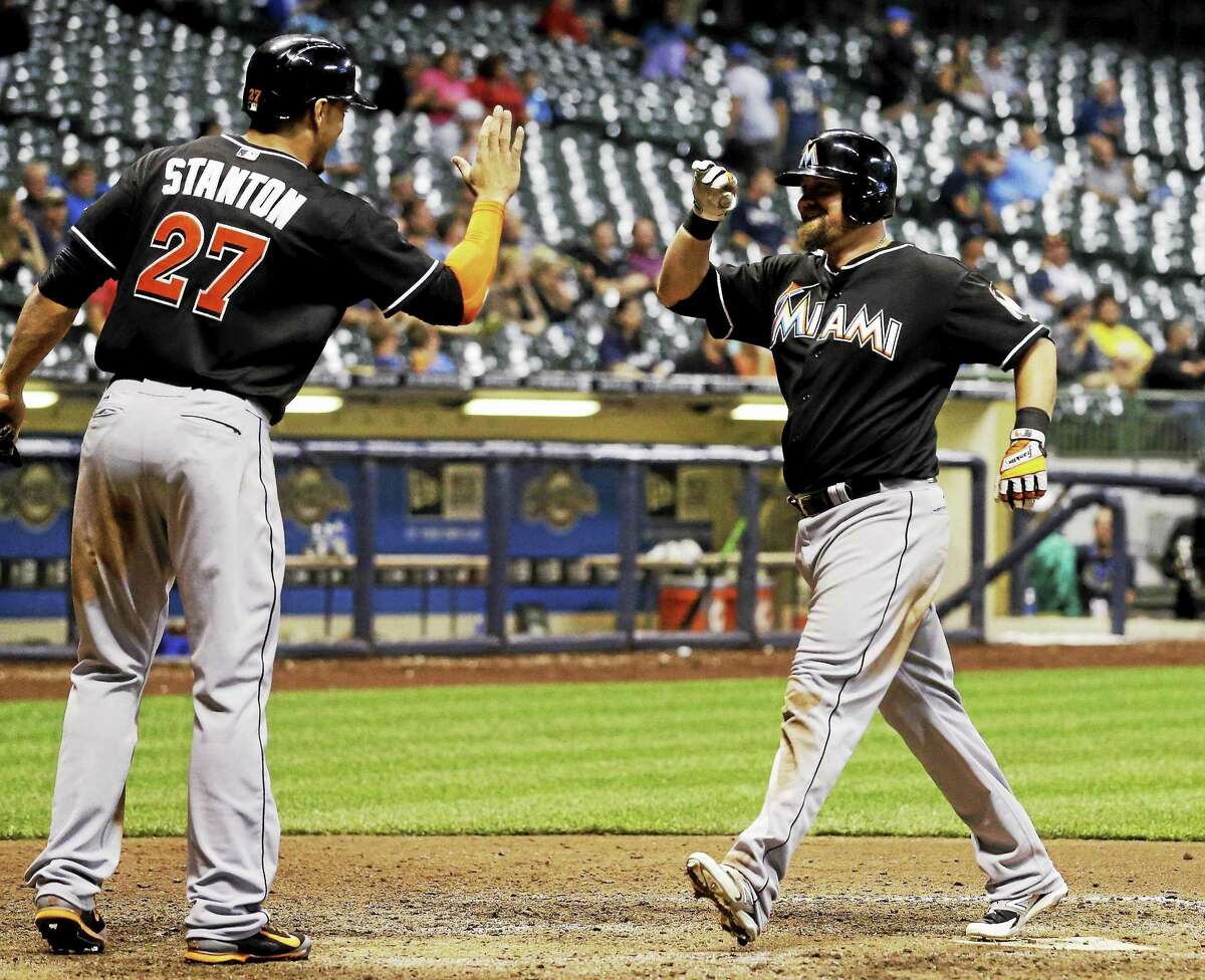 Miami’s Casey McGehee is congratulated by Marlins teammate Giancarlo Stanton after McGehee hit a two-run home run during the ninth inning of a Sept. 9 game against the Brewers in Milwaukee.