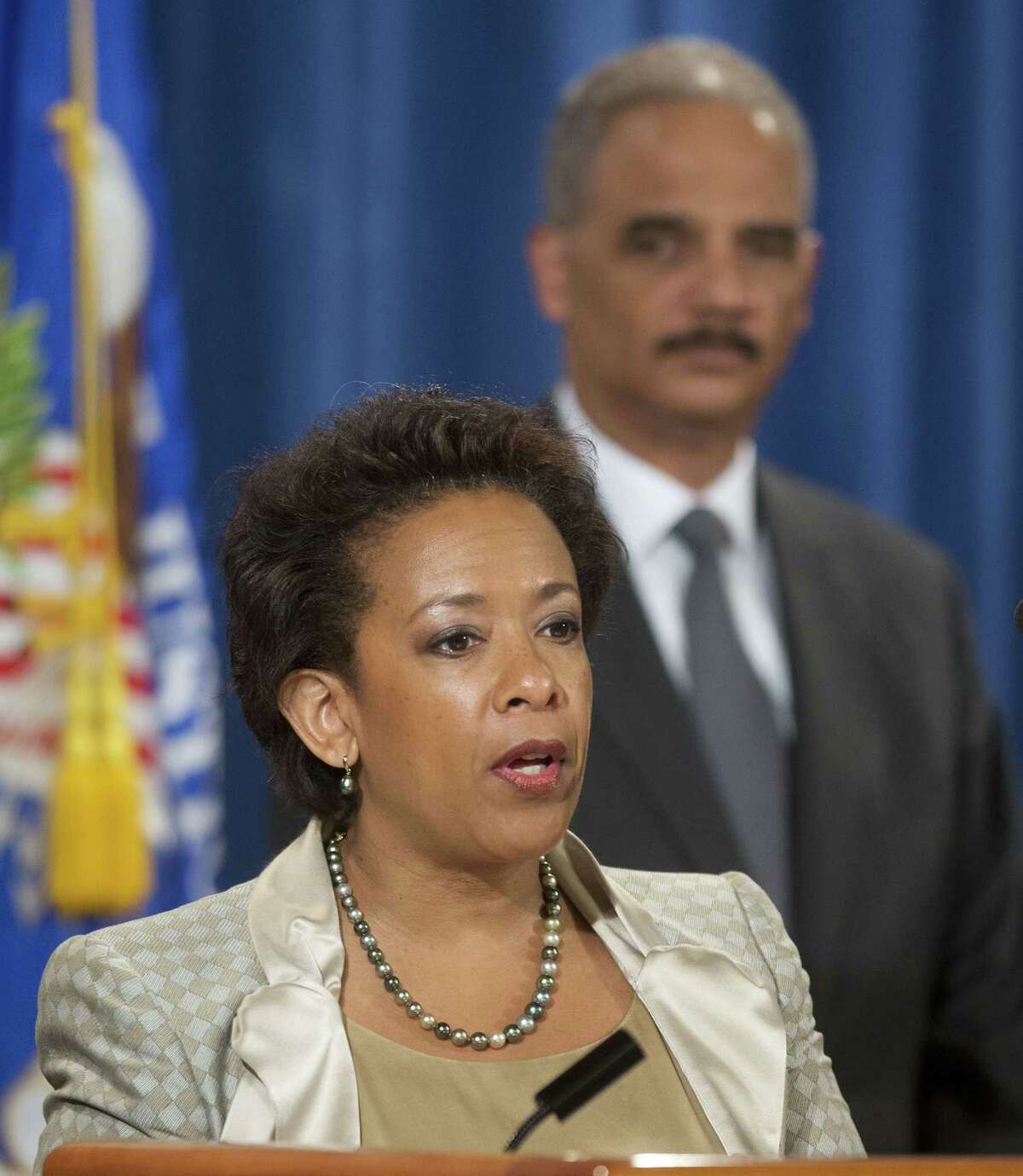 In this July 28, 2014 file photo, Attorney General Eric Holder, right, listens to, Loretta Lynch, left, U.S. Attorney for the Eastern District of New York speaks during a news conference at the Justice Department in Washington. President Obama chose Lynch as attorney general on Friday, Nov. 7, 2014, which would make her the first black woman in the position