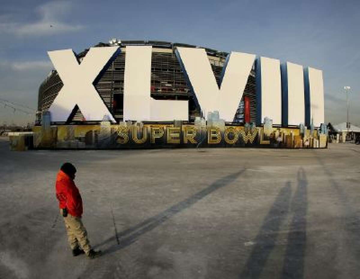 A security guard stands by a sign for NFL football's Super Bowl XLVIII stands in front of MetLife Stadium Saturday in East Rutherford, N.J. The stadium will be the site of Sunday's championship game between the Denver Broncos and the Seattle Seahawks.