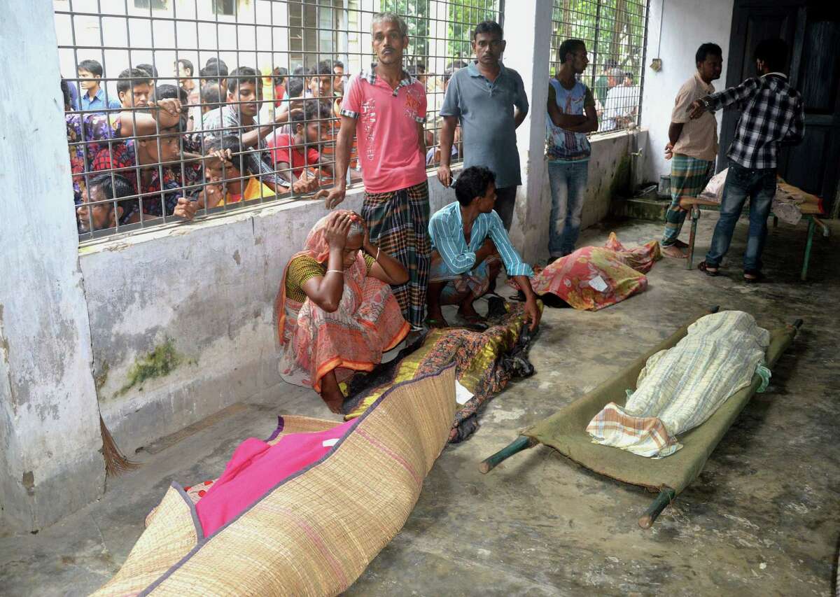 An elderly woman grieves next dead bodies at Mymensingh Medical College Hospital in the town of Mymensingh, 115 kilometers (70 miles) north of Dhaka, Bangladesh, Friday, July 10, 2015. The victims died on a stampede when hundreds of people stormed the home of a businessman for a charity handout during the holy Muslim month of Ramadan, police said. (AP Photo/Jahangir Kabir Jewel)