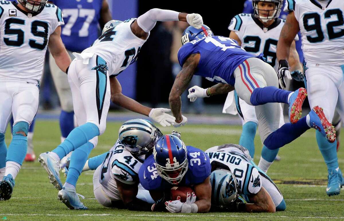 FILE - In this Dec. 20, 2015, file photo, New York Giants' Odell Beckham (13) hits Carolina Panthers' Josh Norman (24) after teammate Shane Vereen (34) was tackled by Kurt Coleman (20) and Roman Harper (41) during the second half of an NFL football game Sunday, Dec. 20, 2015, in East Rutherford, N.J. Beckham, involved in a game-long helmet-smacking, shoving and jawing session with Norman, scored the tying touchdown with 1:46 left in the Giants' 38-35 loss to Carolina. The question for the NFL is why was OBJ still in the game after losing his cool so many times as Norman was getting the best of him in their high-profile matchup. (AP Photo/Julie Jacobson, File)