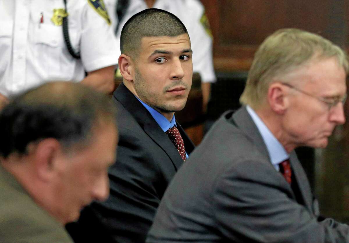 Former New England Patriots tight end Aaron Hernandez, center, looks toward defense attorneys James Sultan, left, and Charlie Rankin, right, during a June 24 hearing in Suffolk Superior Court in Boston.