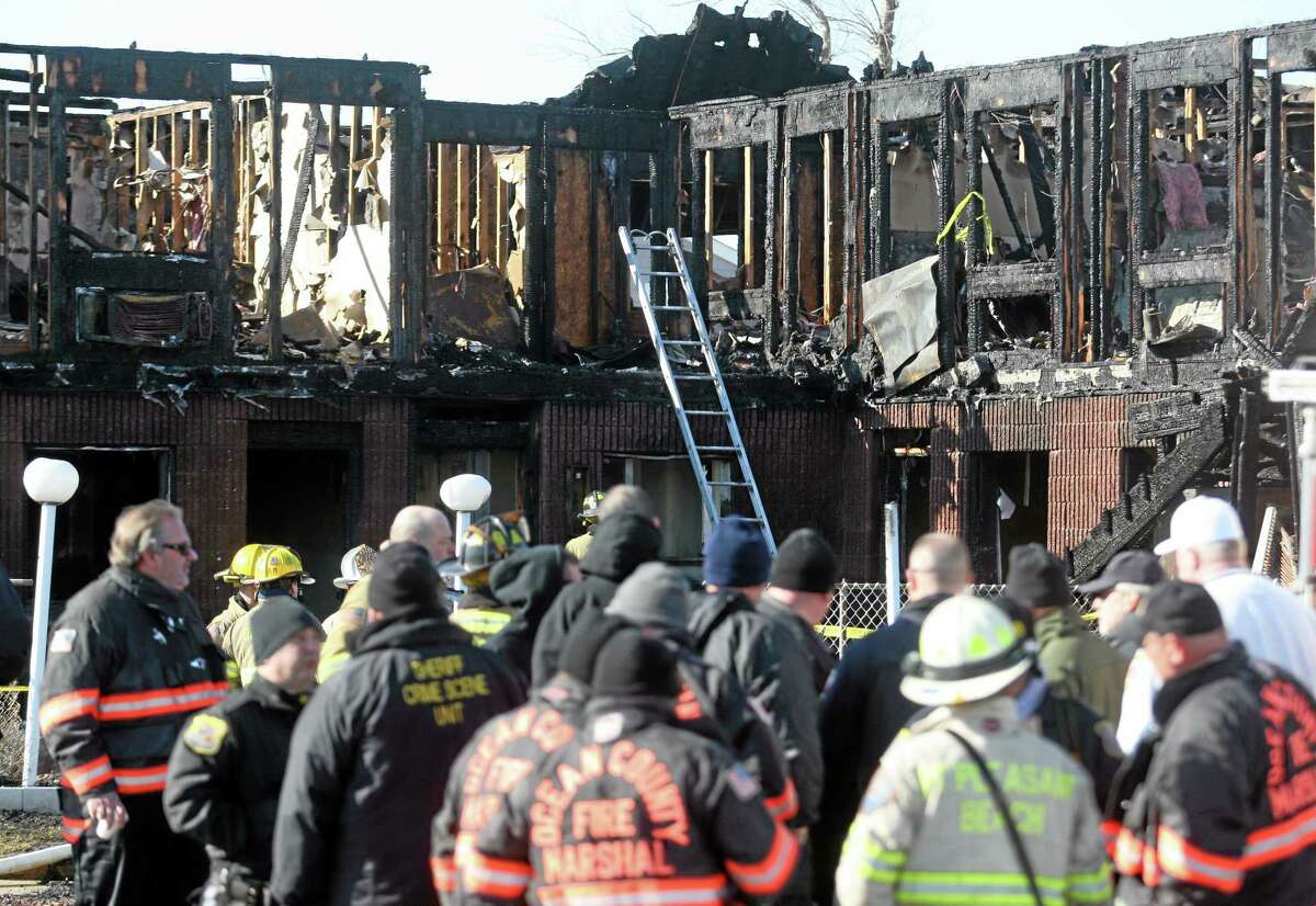 Firefighters investigate an early morning fire at the Mariner's Cove Hotel in Point Pleasant Beach, N.J. on Friday, March 21, 2014. An early morning fire killed three people at the Jersey shore motel whose residents included Superstorm Sandy victims who were staying there because their homes remain uninhabitable nearly a year and a half after the storm, officials said. Three other people were critically injured in the blaze. Authorities said several other people may be unaccounted for. Investigators are interviewing motel management to determine how many people were staying there when the fire broke out. The motel's office was destroyed and most records were lost. (AP Photo/David Gard)