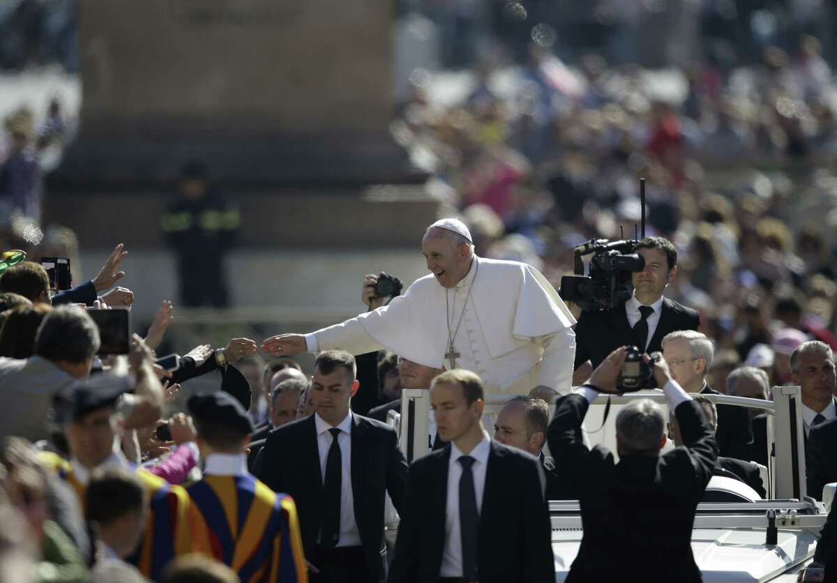 Pope Francis, center, waves to faithful as he arrives for his weekly general audience, in St. Peter's Square, at the Vatican, Wednesday, April 22, 2015. (AP Photo/Gregorio Borgia)