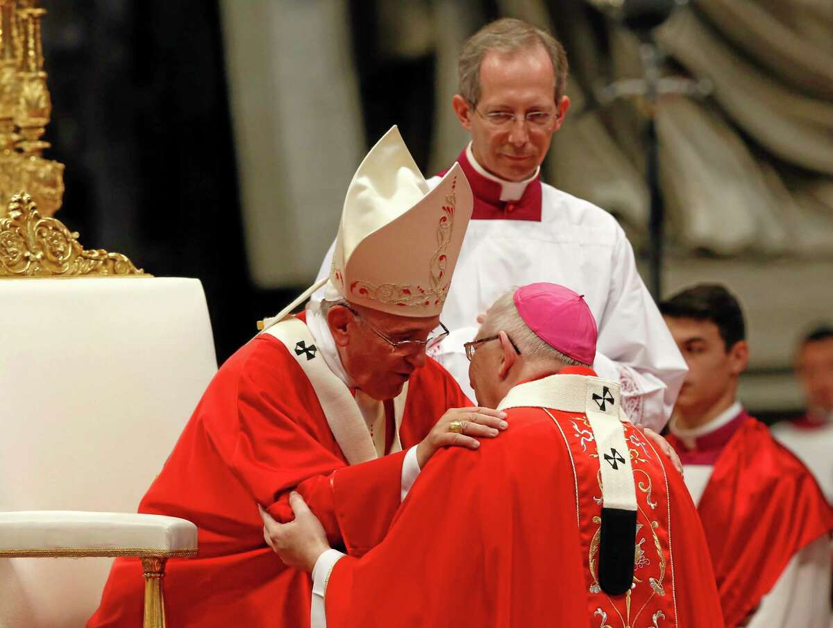 Pope Francis greets Leonard Paul Blair, kneeling, archbishop of Hartford, after bestowing on him the pallium, a woolen shawl symbolizing a bishop’s bond with the pope, during Sunday Mass in St. Peter’s Basilica at the Vatican.